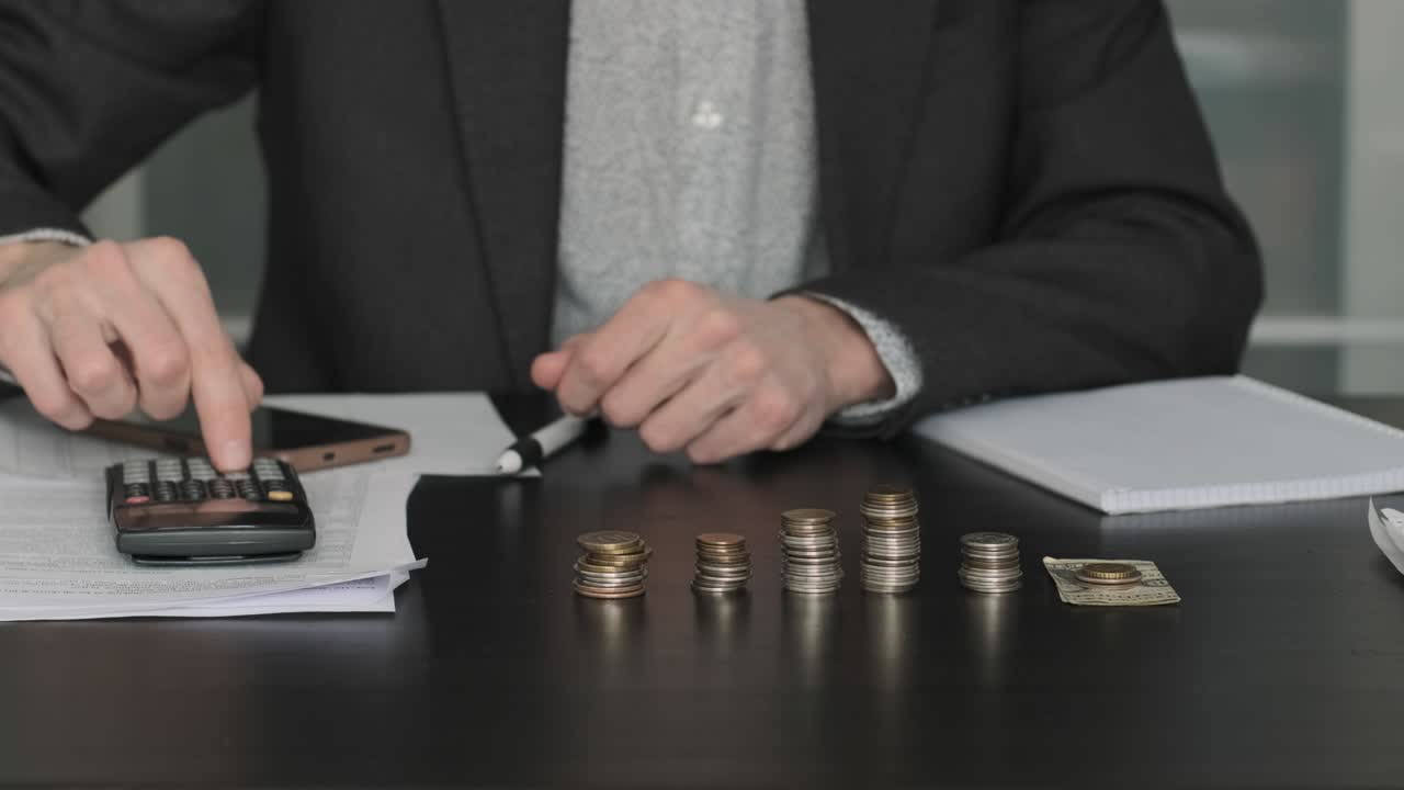 cerca de la mano masculina apilando monedas y contando