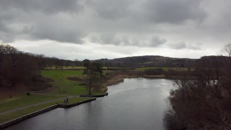 Imágenes-Aéreas-Cinematográficas-De-Un-Pie-Caído-En-El-Lago-Windermere,-Un-Parque-A-Orillas-Del-Lago-Con-Impresionantes-Vistas-De-Las-Montañas-De-Cumbria