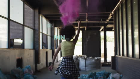 female artist holding smoke canister walking industrial corridor, with animated tech word cloud