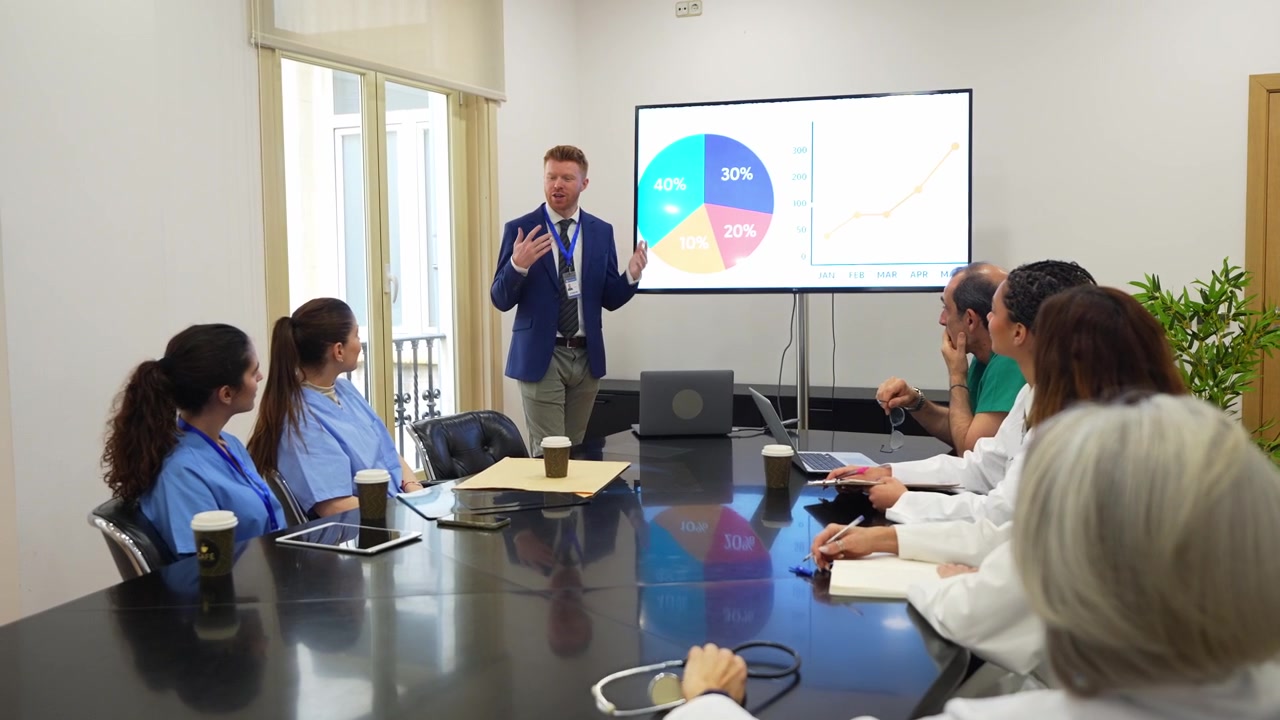 Medical Professional Giving Presentation to Healthcare Team in Conference Room