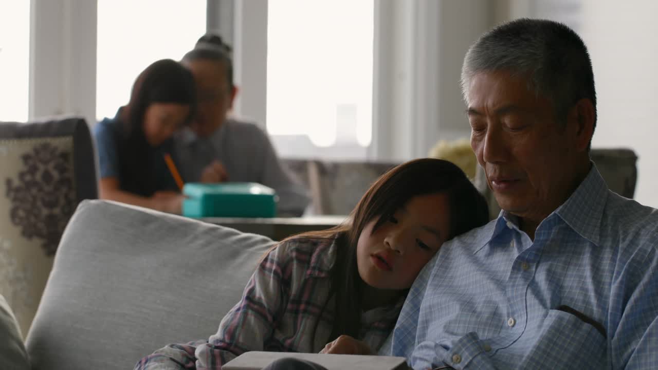 집에서 디지털 태블릿 4k를 사용하는 귀여운 아시아 손녀와  ⁇ 은 고령 할아버지의 앞면