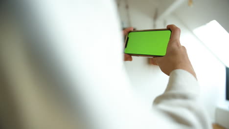 close up shot of man using his smart phone with mock up green screen in horizontal, social media 4k video template