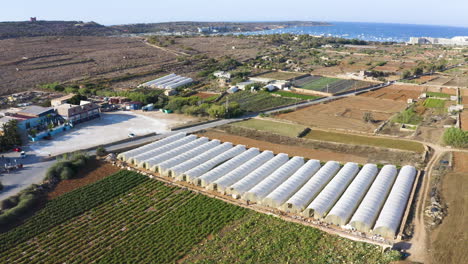 coastal farmland countryside with silos,malta seaside,aerial zooming