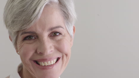 feliz mujer de mediana edad sonriendo mirando a la cámara disfrutando de un exitoso estilo de vida de jubilación en un fondo en blanco copia el espacio de cerca