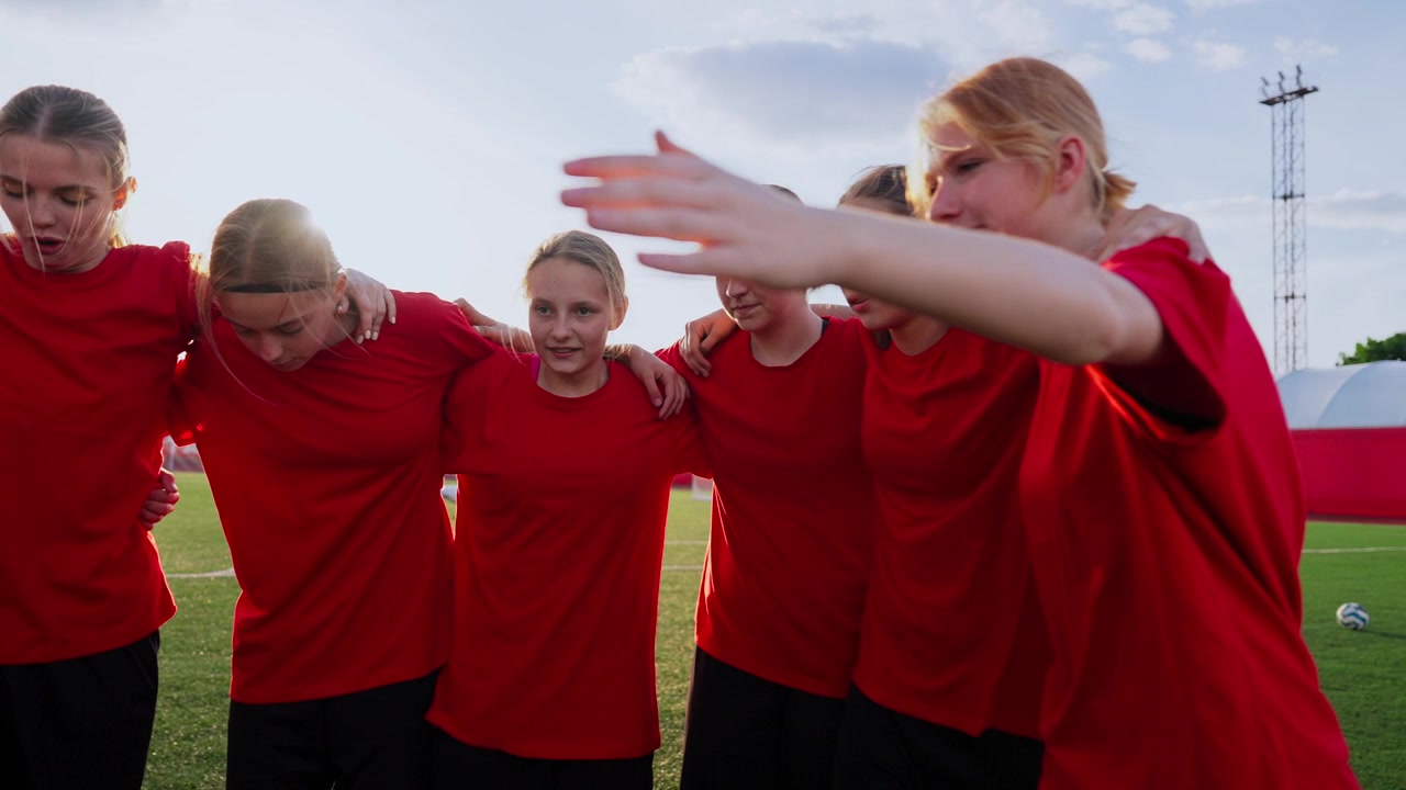 Young Female Soccer Team Huddling Together on Field