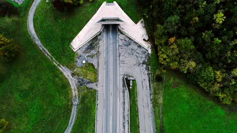 wonderful aerial view over highway roads going into a tunnel in france. only grass fields and trees around the roads. cars and trucks driving on the roads.