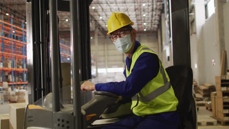 portrait of asian male worker wearing safety suit and face mask in warehouse