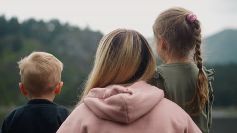 family of mother and children rests enjoying mountains