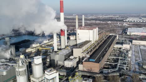 white steam pushed into the air from a chimney of a coal-fired thermal power plant