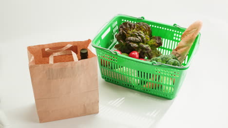 person shopping for groceries with paper bags and a shopping basket