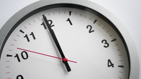 close up of a white ticking clock on white background, pointing midnight, window reflection, time lapse