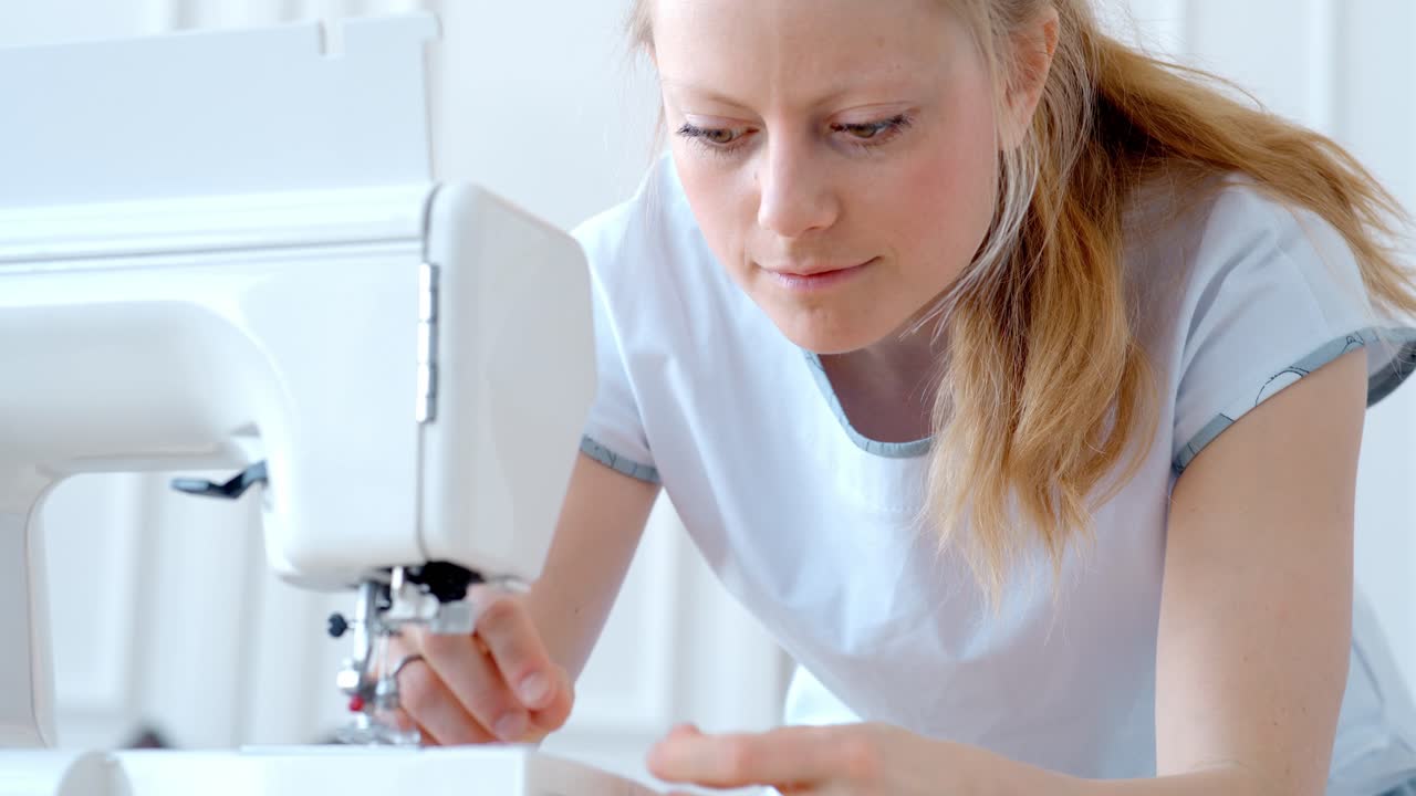 Woman Carefully Working on Sewing Machine