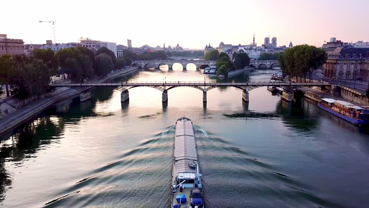 Nave da carico che naviga sulla calma Senna mattutina e si dirige verso il Pont des Arts.