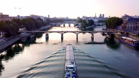buque de carga flotando en el tranquilo río sena por la mañana y dirigiéndose a pont des arts
