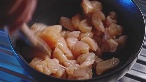 mixing chopped uncooked chicken breast with salt and pepper in a bowl