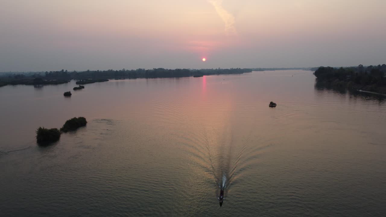 라오스 남쪽의 거대한 메콩 강에서 시이 해가 지기 전에 집으로 돌아오고 있습니다.