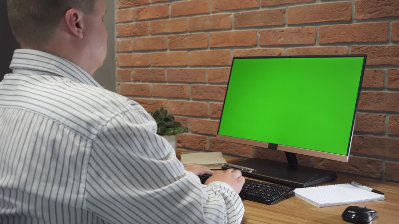 hombre trabaja en la computadora personal con pantalla de maqueta verde en la oficina