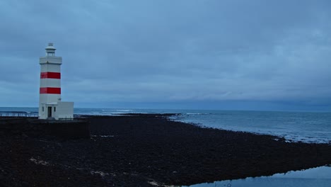 stunning view of an old lighthouse on black sand beach in iceland