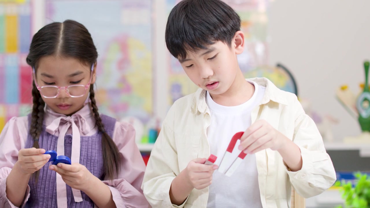 밝은 교실에서 다채로운 자석으로 실험하는 두 명의 초등학생, 정적인 미디엄 샷, 부드러운 조명.