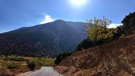 pov disparado mientras conducía por un camino rural en creta, grecia y capturando montañas durante la tarde