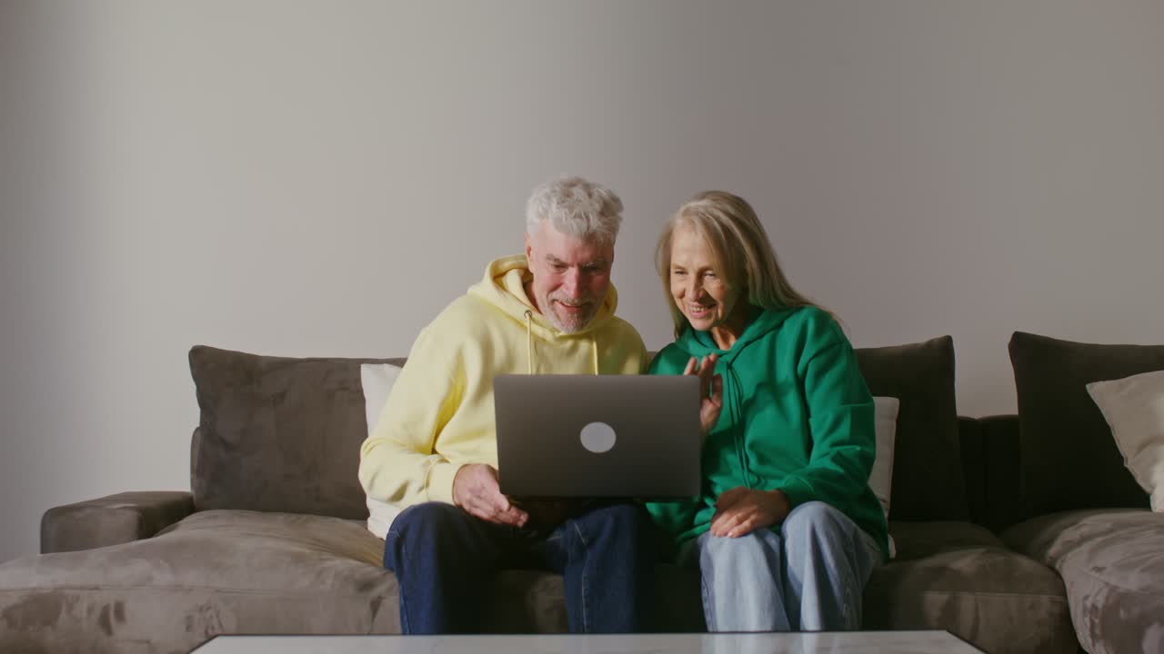 una pareja mayor haciendo una llamada de video en una computadora portátil