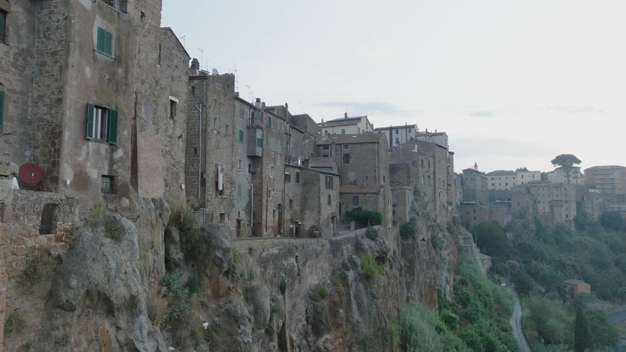Aerial Drone view of the hilltop Medieval town of Pitigliano, Tuscany in morning light flying near old buildings and rooftops, in 4K