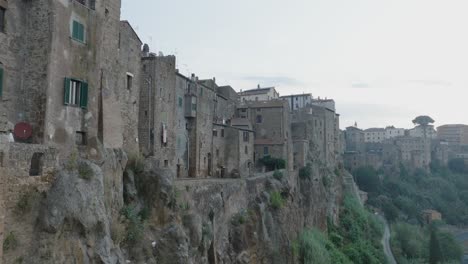 aerial drone view of the hilltop medieval town of pitigliano, tuscany in morning light flying near old buildings and rooftops, in 4k