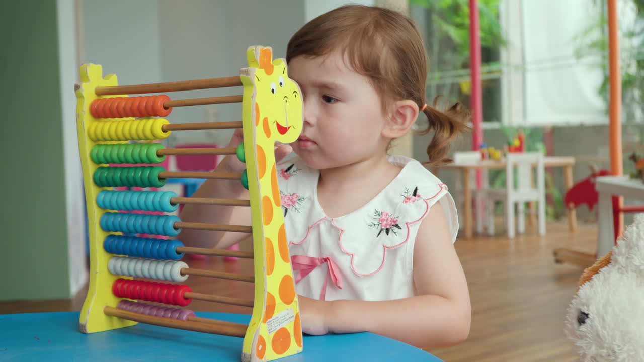 la niña cuenta en el ábaco con cuentas de colores
