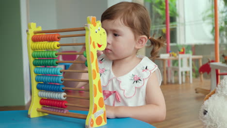 little girl count on abacus with colorful beads