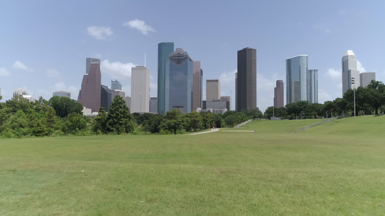 este video trata sobre una vista aérea de ángulo bajo del centro de houston desde un parque cercano.