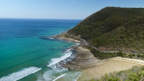 a stunning aerial view of the great ocean road, showcasing dramatic cliffs, the ocean, and lush landscapes from a high vantage point.