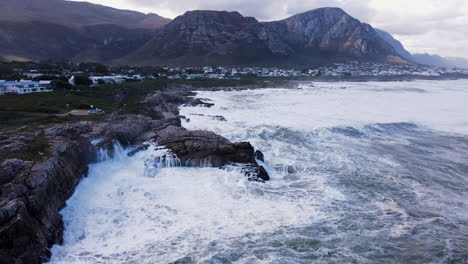 Crashing-wave-into-rocks-splash-impressively-in-white-cloud,-Hermanus