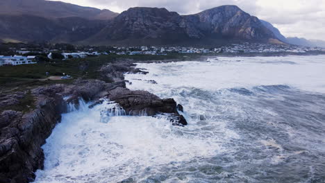 la ola chocando contra las rocas salpica impresionantemente en la nube blanca, hermanus