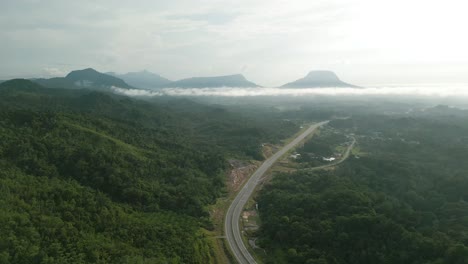 beautiful drone view of bau to lundu pan borneo highway during morning sunset with mountain and valley, green forest,sarawak, borneo.