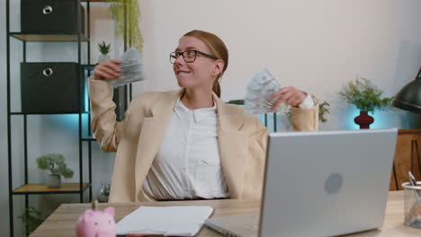 Feliz-Mujer-De-Negocios-Trabajando-En-La-Computadora-Portátil-De-La-Oficina-Regocijándose-Por-Ganar-Recibiendo-Dinero-En-Efectivo-éxito-Lotería-Suerte