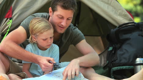 father teaching his son to use a map