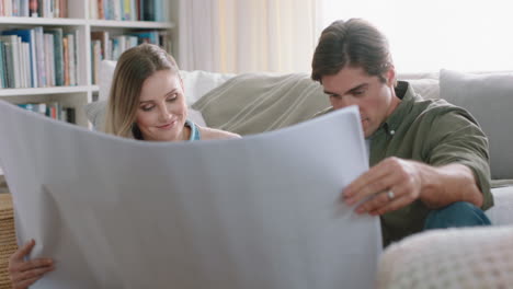 young couple looking at architectural plan of house planning home renovation project discussing interior design layout of floor plan sharing ideas 4k footage