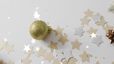 golden bauble with christmas decorations over star confetti animation