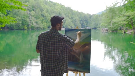 painter painting against the lake.