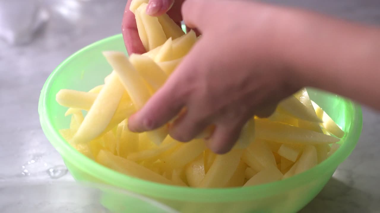 cortar la patata en la encimera para hacer papas fritas