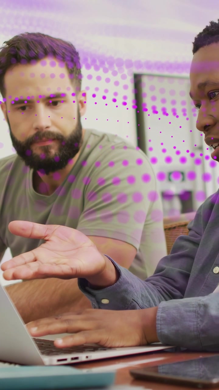 Vertical video: Two men at laptop content starting tech review, typing, pointing, purple overlaying