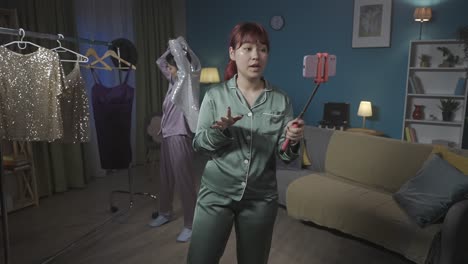 two women in pajamas recording a fashion video