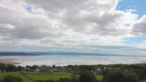 Timelapse-of-the-coastal-landscape-over-a-bay-with-the-water-receding,-bright-summers-day