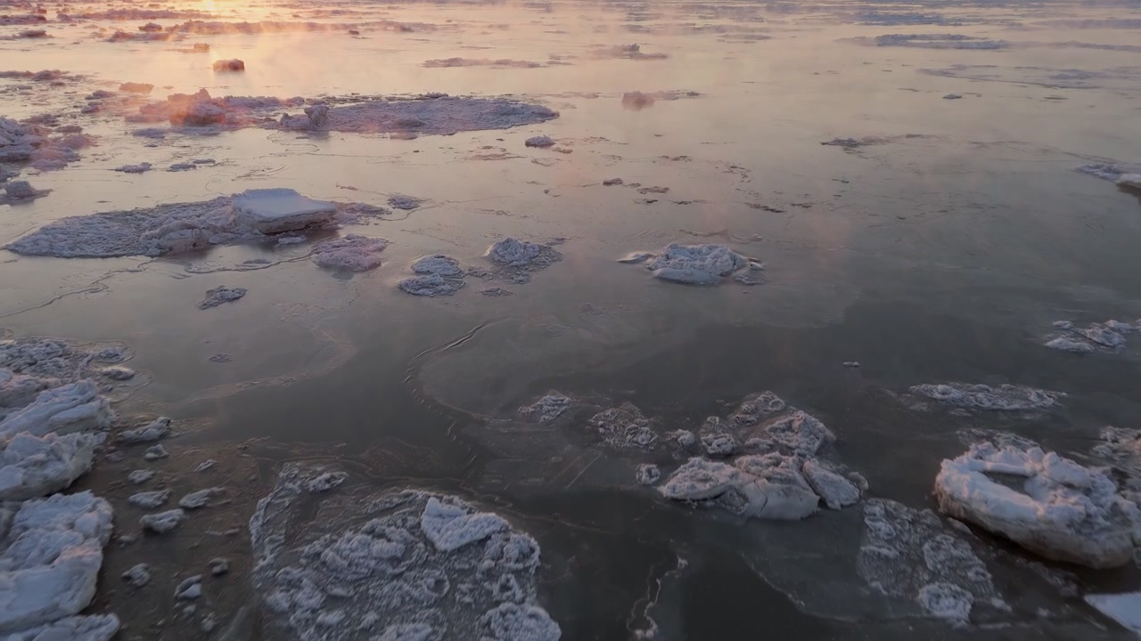 Merisavua nousee sohjon yllä auringonlaskun aikaan, drone lentää matalalla ja hitaasti veden yllä