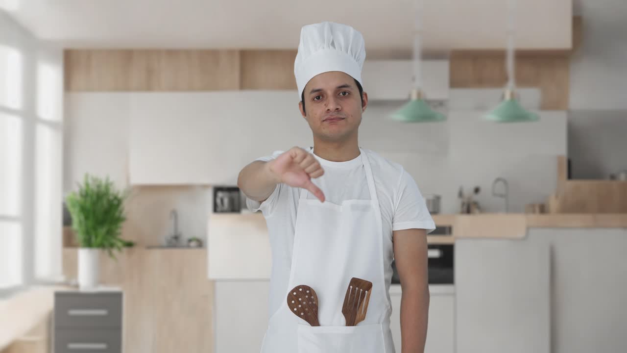 chef profesional indio decepcionado mostrando los pulgares hacia abajo