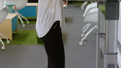 female executive talking on mobile phone while exercising on treadmill 4k