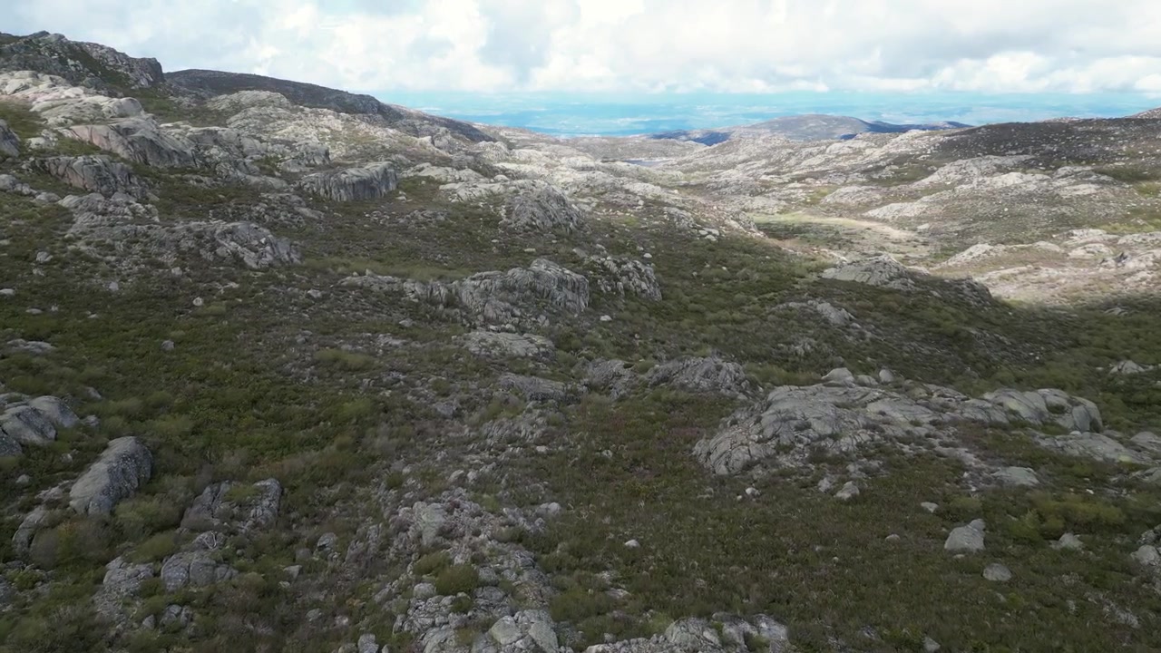 Luftoptagelser med drone af Serra da Estrela, Portugal: klippefyldte bjergtoppe, vandreservoirer og et stort naturlandskab under klart lys. Ideel til rejse- og naturprojekter