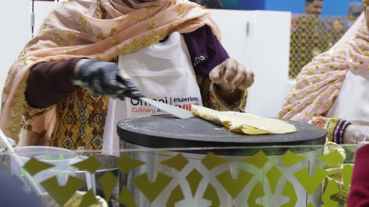 Food Vendor Cooking And Selling Traditional Omani Bread. medium shot