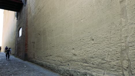 people walking through a historic stone alley