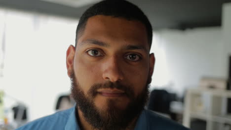 handsome young bearded man looking at camera